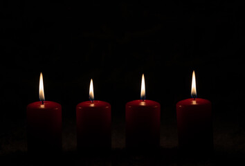 Four burning candles in the dark night