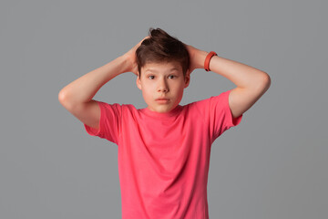 Portrait of alarmed teenager boy, dont know what do, grab head looking with disbelief and panic, standing frustrated, got in trouble, gray background