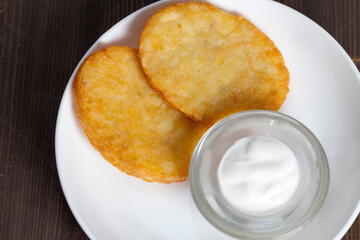 potato pancakes with sour cream on a plate