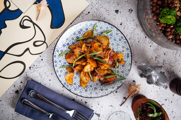 Portion of rustic fried potatoes dish on decorated background