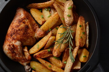 Baked chicken leg quarter and drumstick seasoned with garlic and herbs with potatoes in a baking...