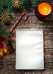 A white notepad on dark wooden background in Christmas setting