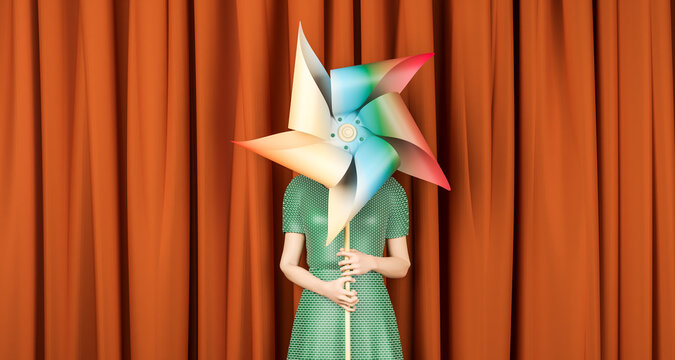 Woman holding pinwheel toy in front of brown curtain