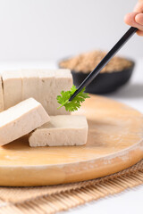 Sliced fresh tofu on wooden board decoration with coriander leaf, Vegan Food ingredients in Asian food