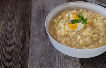 Bowl with egg salad isolated on wooden table