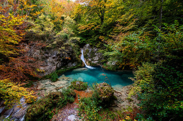 Forest turquoise blue lake with white marble stones and waterfalls in Nature Park Urbasa-Andia, Urederra.