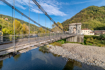The ancient Ponte delle Catene bridge, that connects Chifenti with Fornoli, Lucca, Italy, above the Lima stream - obrazy, fototapety, plakaty