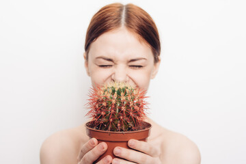 woman with bare shoulders with a cactus in her hands