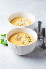 Vegetarian cream cheese soup with cauliflower in white bowl. Healthy vegan food concept.
