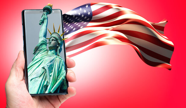 USA Symbols On Phone. Human Hand With Flag And Statue Of Liberty. Statue Of Liberty In Mobile App. Visualization Of America Flag On Red Background. USA Symbols. Statue Of Liberty Symbolizes New York