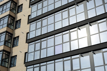 Facade of a new modern building with glass balconies in the concept of a modern city. Bottom view