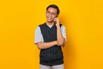 Portrait of attractive Asian man talking on smartphone and looking happy