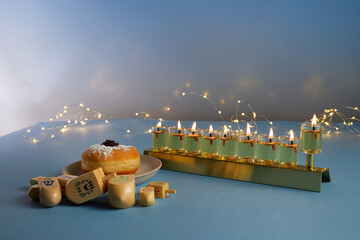 Jewish holiday Hanukkah background with menorah- traditional candelabra, spinning top and doughnut...