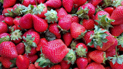 Background of ripe strawberries in a box. A box of red juicy strawberries in close-up. Top view