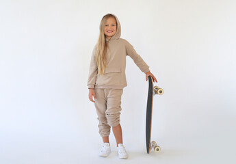 Beautiful girl holds a skateboard and smiles