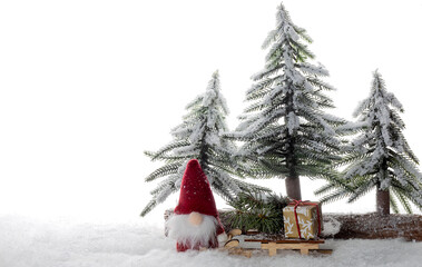Christmas present on the wooden sled and gnomes in the snow forest on the white background ,copy space