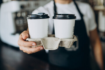 Male barista with take away coffee