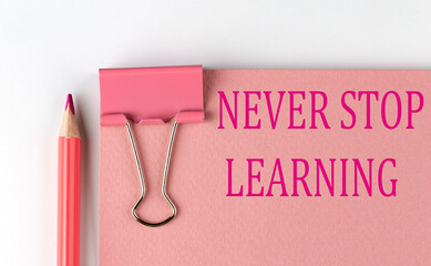 NEVER STOP LEARNING word on pink paper with pink pencil