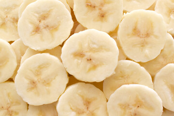 Banana slices on a bamboo chopping board texture background.  