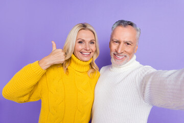 Fototapeta na wymiar Photo of shiny cute senior husband wife dressed knitwear sweaters hugging tacking selfie showing thumb up smiling isolated violet color background