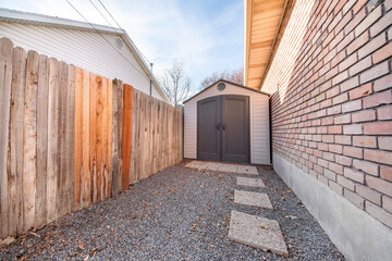Plastic shed outside a house with concrete pathway
