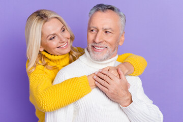 Photo of adorable cute mature wife husband wear knitted pullovers smiling embracing looking eyes isolated purple color background
