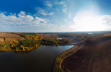 Aerial wide view of lake at sunrise in autumn. Meadows, orange grass. Colorful landscape of river sunset. Horodok Ukraine Fishermen by the river are fishing. Leisure and hobbies. A park old mill
