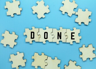 wooden puzzle with the word donedan blue background