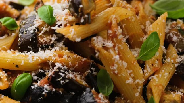Eating Pasta alla Norma with eggplant or aubergine, tomato, parmesan and basil