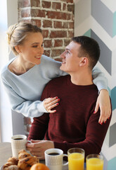 Young happy lovely couple have breakfast in the early morning at home