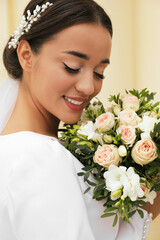 Young bride with beautiful wedding bouquet outdoors