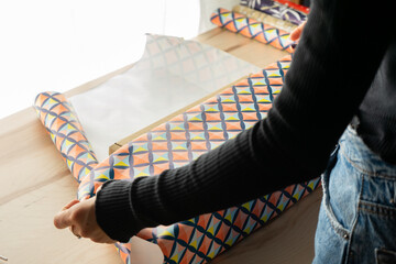 girl wrapping a gift with colored paper