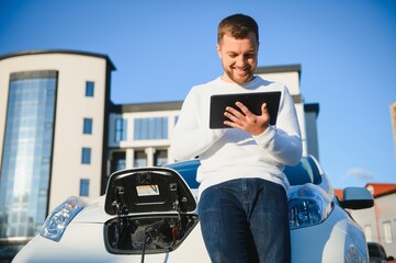 Man charges an electric car at the charging station
