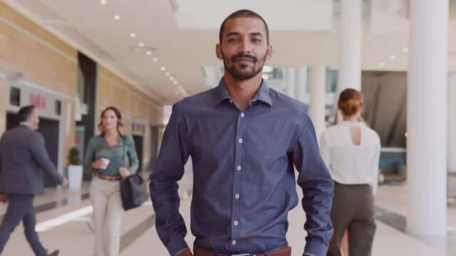Proud businessman walking in modern office building