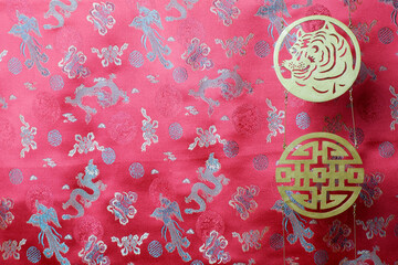 Golden chinese tiger and prosperity symbols on red fabric with chinese ornament birds and dragons. Chinese New Year of the Tiger 2022