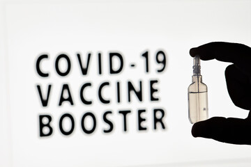 Covid-19 Vaccine booster dose. Hand of the doctor holds a new Covid vaccine booster dose vial