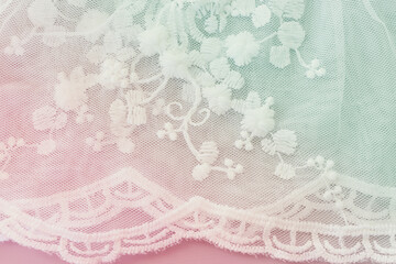 Background of white delicate lace fabric, pastel toned