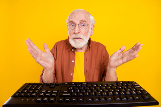 Photo of clueless ignorant grandpa sit computer stupor reaction wear specs brown shirt isolated yellow color background