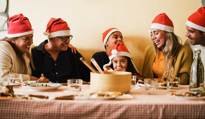 Happy latin family having fun eating dinner together during Christmas time - Holiday concept - Main...
