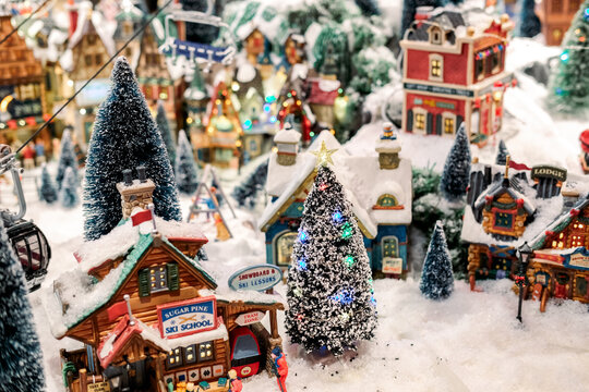 Christmas diorama decor in store window. Winter village in miniature. dynamic toy winter town, carousel, residents, snow, Santa Claus and trees. Milan, Italy, November 7, 2021