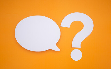 Speech bubble concept. An empty speech balloons and question mark symbol isolated on yellow background with copy space for text. Close-up photo. Top view