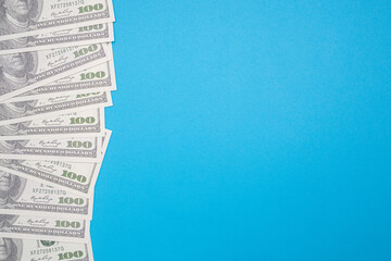 Naklejka premium One hundred US dollars bills pile isolated on blue background with copy space for text. Business and finance concept