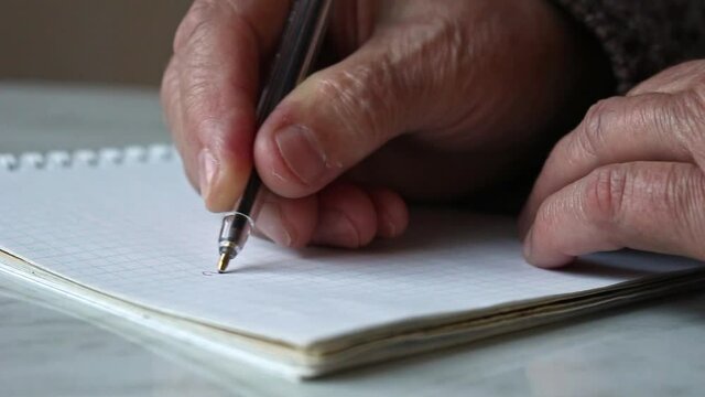 Hands of an old woman with a sheet for writing text.