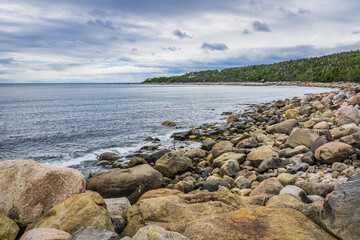 View on the rocky shore of St Lawrence river near Baie Comeau, in Cote Nord region of Quebec, Canada