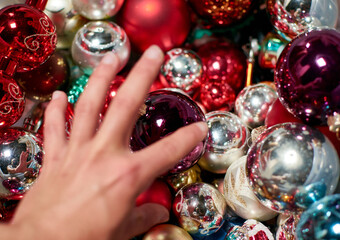 A hand taking a Christmas tree ball