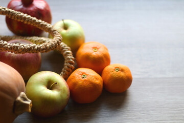 Straw tote bag filled with butternut squash and various fruit. Selective focus.