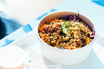 Poke bowl with salmon or tuna, avocado, beans and lot of different ingredients ready for take out