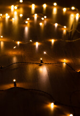 christmas, holidays and illumination concept - close up of electric garland lights in darkness