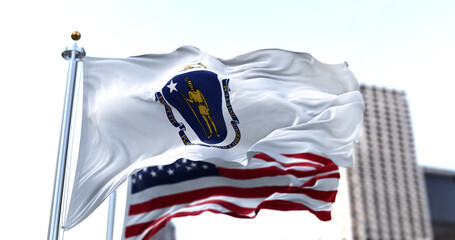 Naklejka premium the flag of the US state of Massachusetts waving in the wind with the American flag blurred in the background