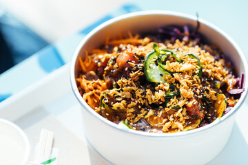 Poke bowl with salmon or tuna, avocado, beans and lot of different ingredients ready for take out